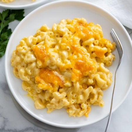 Baked Mac and Cheese on a white plate with a fork on the side.