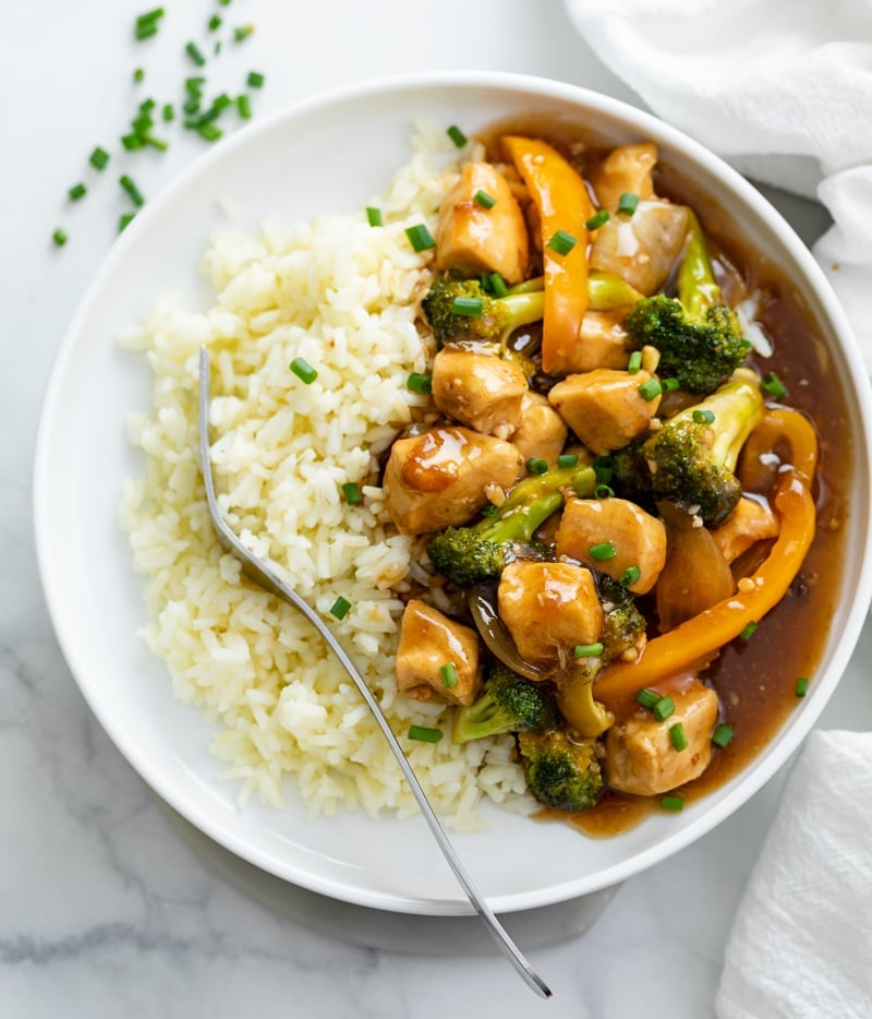 A white plate with Chicken and Broccoli and Rice.