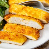 Slices of crispy breaded chicken Milanese on a plate.