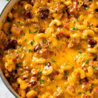 A pot filled with Chili Mac topped with melted cheese.