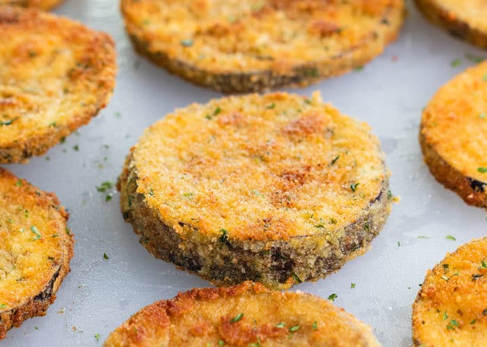 slices of fried eggplant on a white cutting board. 