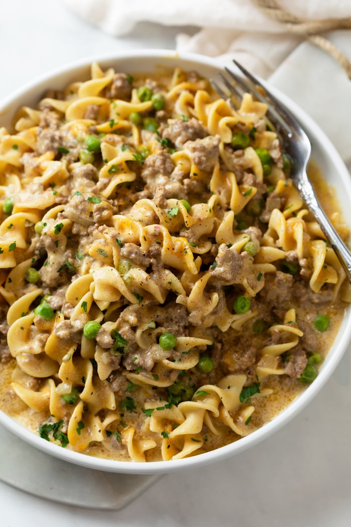 Overhead view of a white plate with Ground Beef Casserole and a fork on the side.