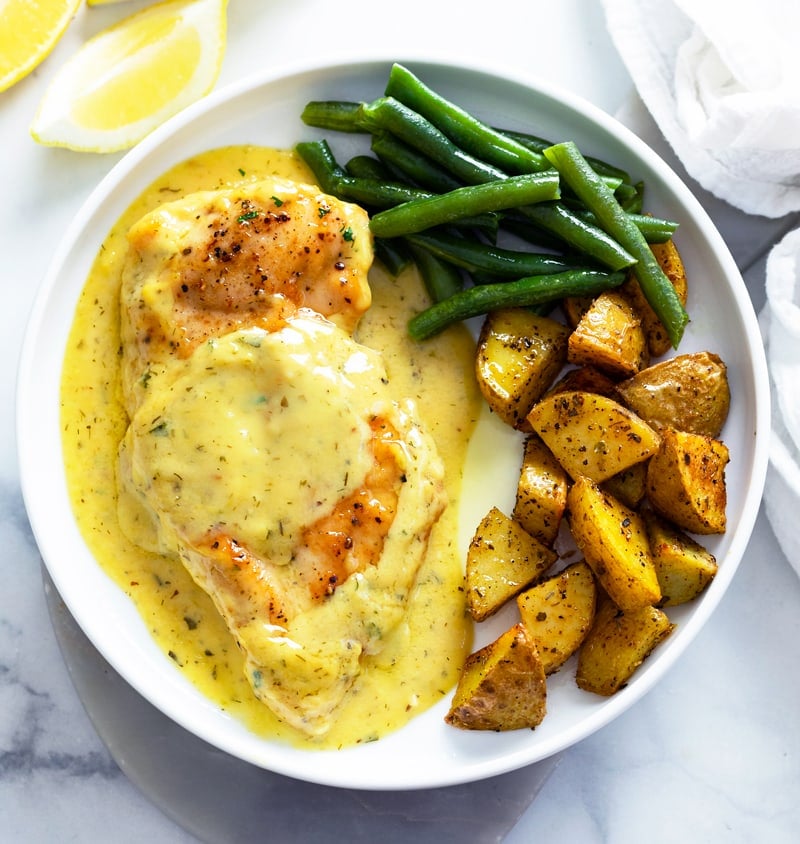 Honey Mustard Chicken on a white plate with green beans and roasted potatoes.