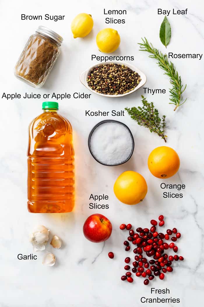 Ingredients for making a wet brine turkey on a white surface with labels.