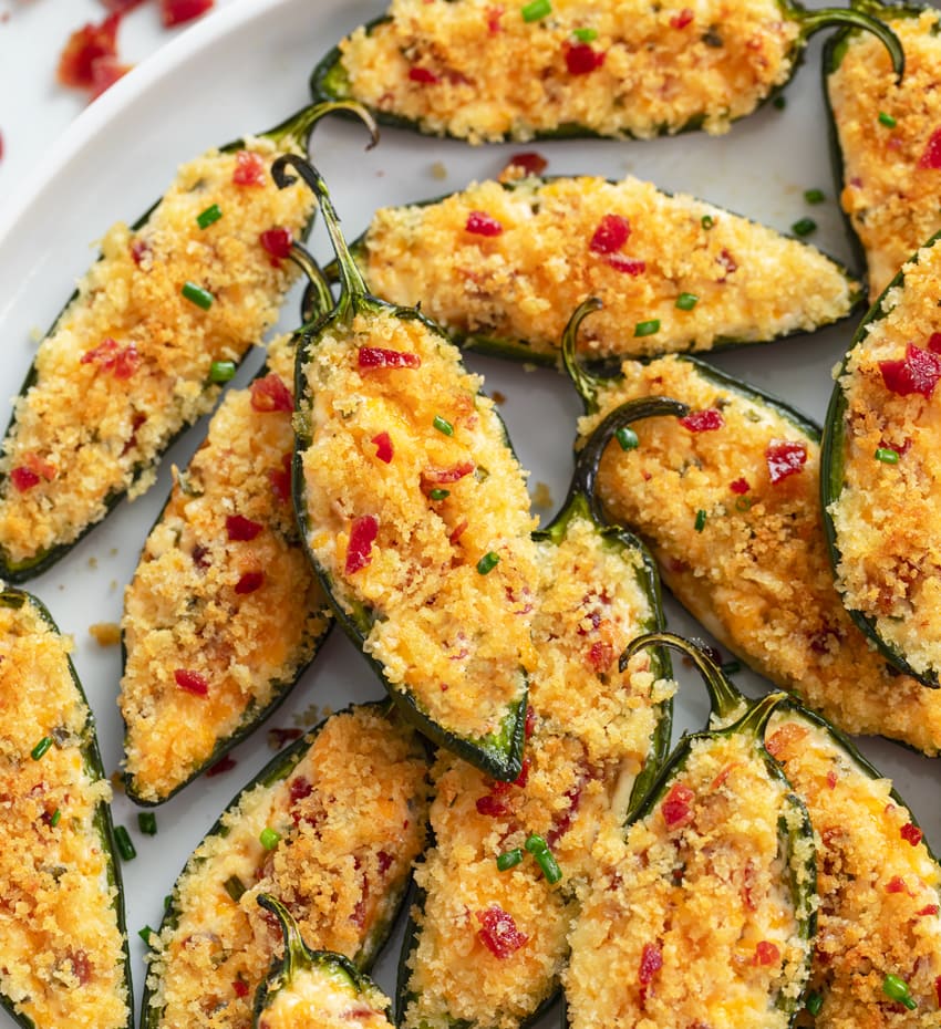 A plate of Jalapeno Poppers with panko breading on top and a cream cheese filling.