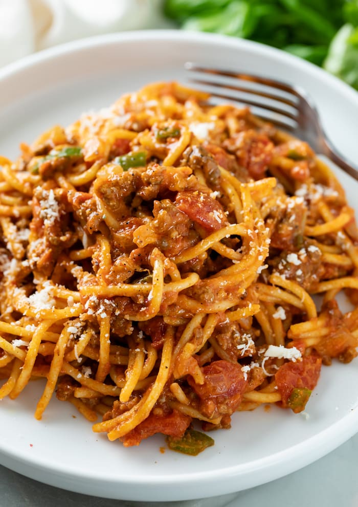 A white plate topped with One Pot Spaghetti in meat sauce.