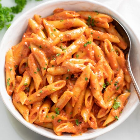 A bowl of Penne Alla Vodka with parsley on top.