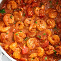 Shrimp Fra Diavolo in a skillet with chunky tomatoes and fresh parsley.