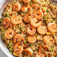 Shrimp Fried Rice in a skillet with eggs and vegetables in a brown sauce.