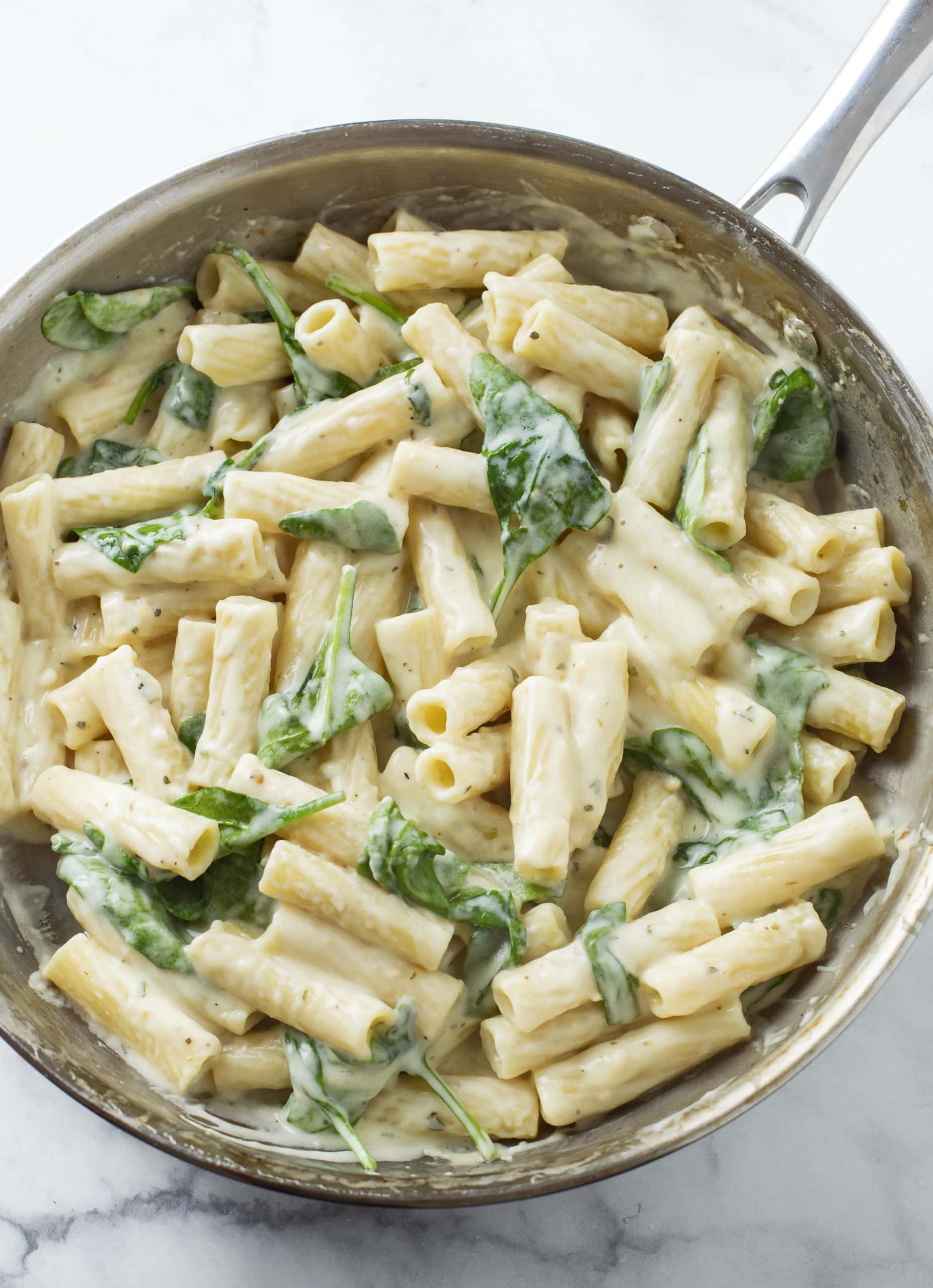 A silver skillet filled with Creamy Broccoli Pasta in a Garlic Parmesan Sauce.