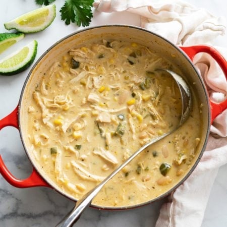 A soup pot filled with White Chicken Chili with a ladle in it.