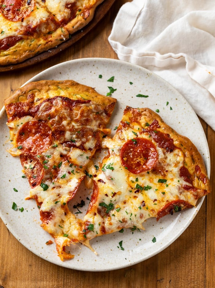 A plate with 2 slices of zucchini crust pizza with cheese and pepperoni.